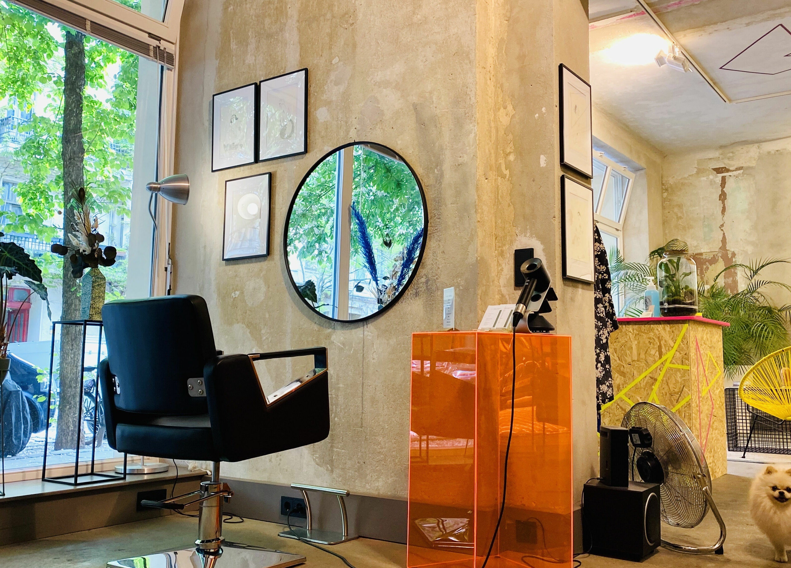 Inside Marc-Antoine Hairstudio Gallery, Berlin, Berlin, DE. Stylish chair facing mirror with lush green views.