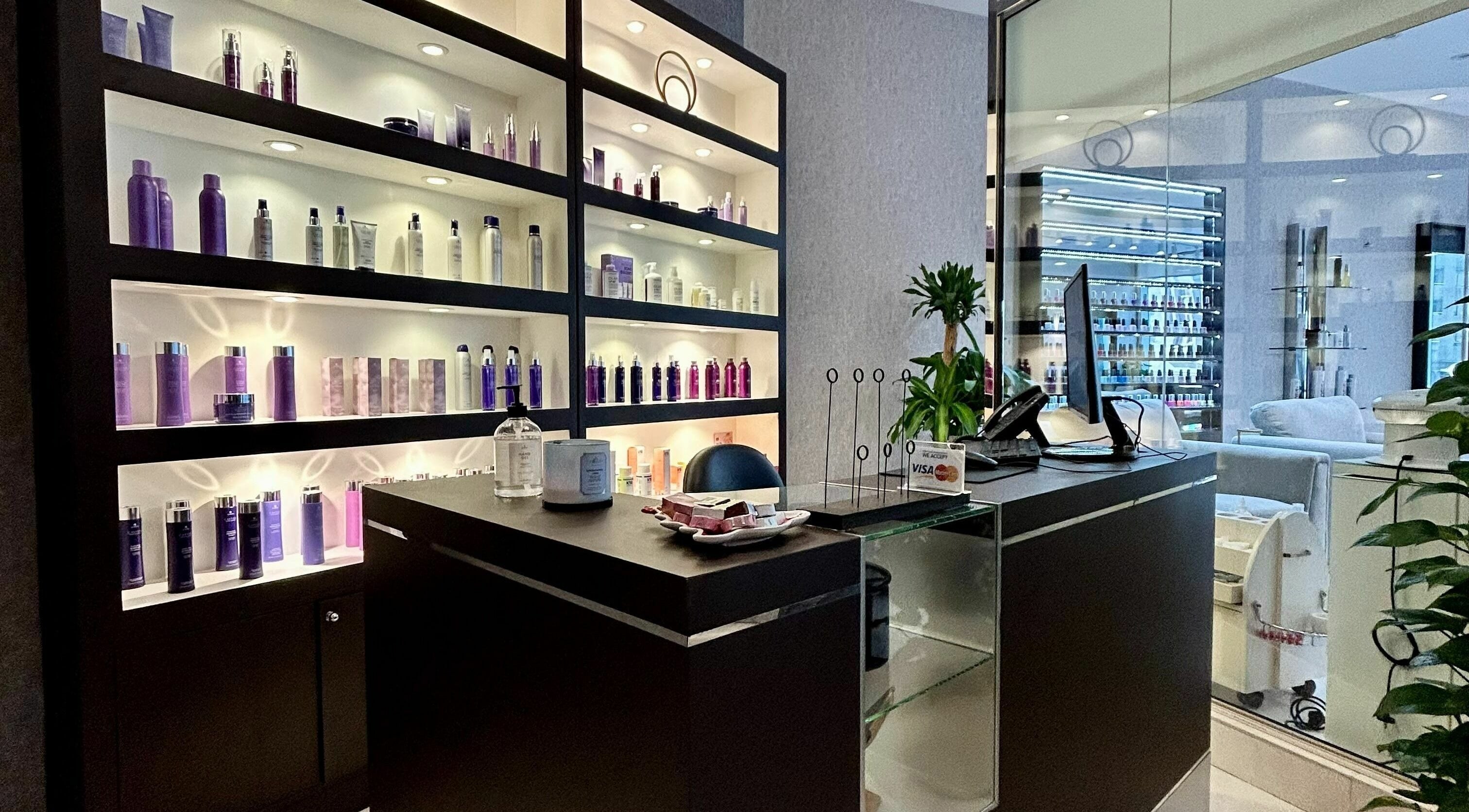 Reception area at Venere By Ann Ladies Salon in Abu Dhabi, showcasing products on sleek, lit shelves.