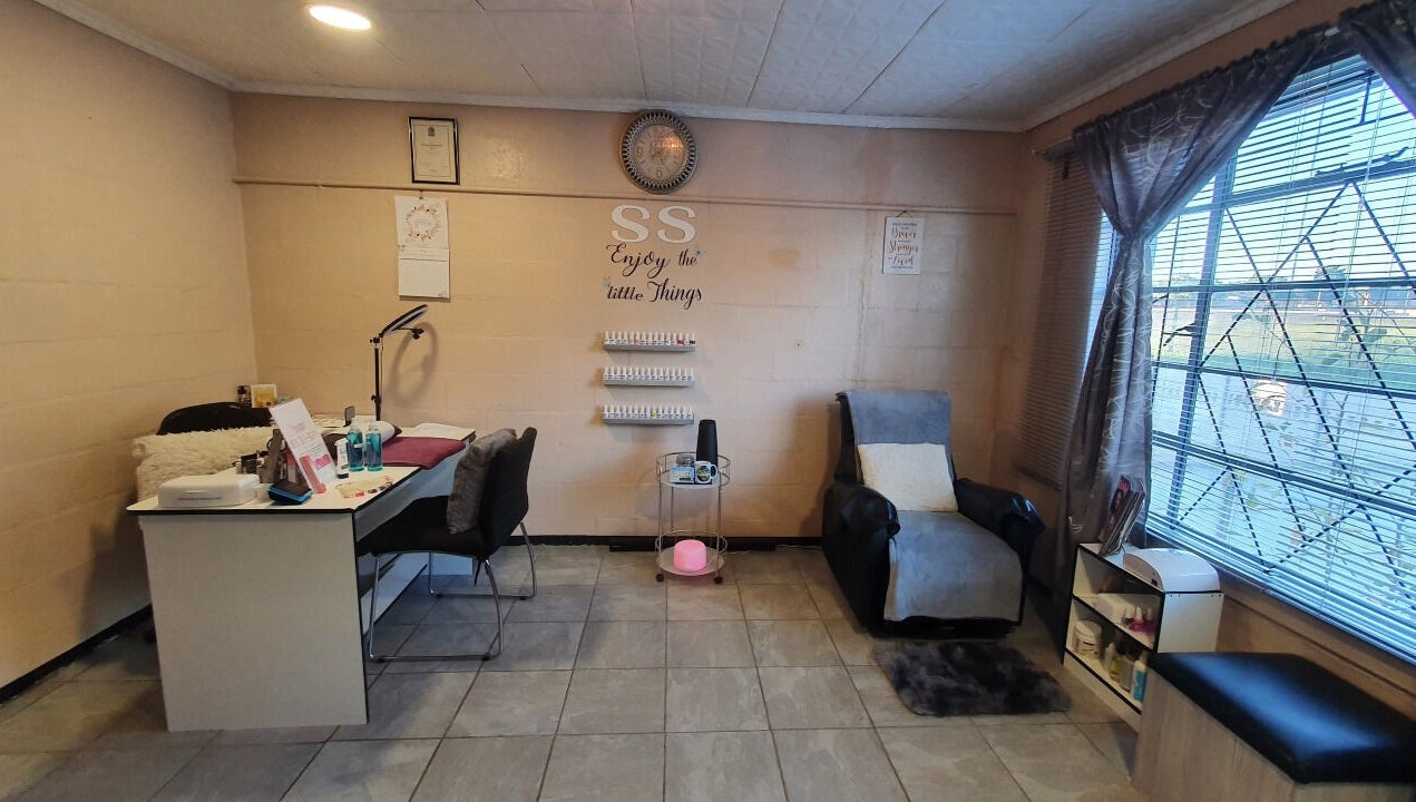 Cozy room at Sass Spa in Cape Town, Western Cape, ZA with a massage chair and nail desk.