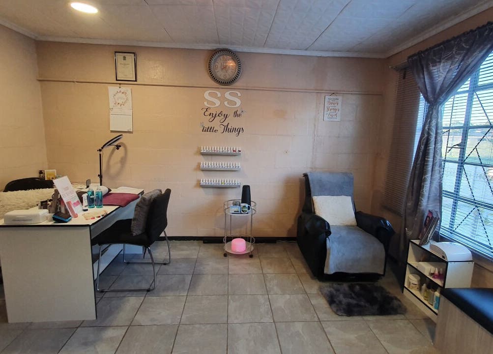 Cozy room at Sass Spa in Cape Town, Western Cape, ZA with a massage chair and nail desk.