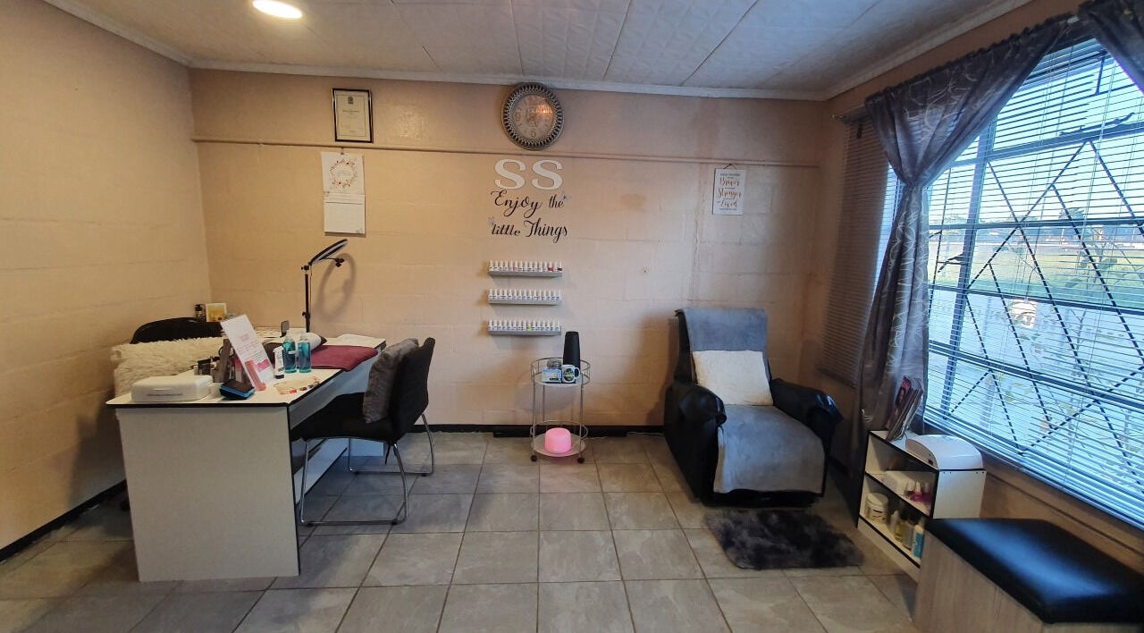 Cozy room at Sass Spa in Cape Town, Western Cape, ZA with a massage chair and nail desk.