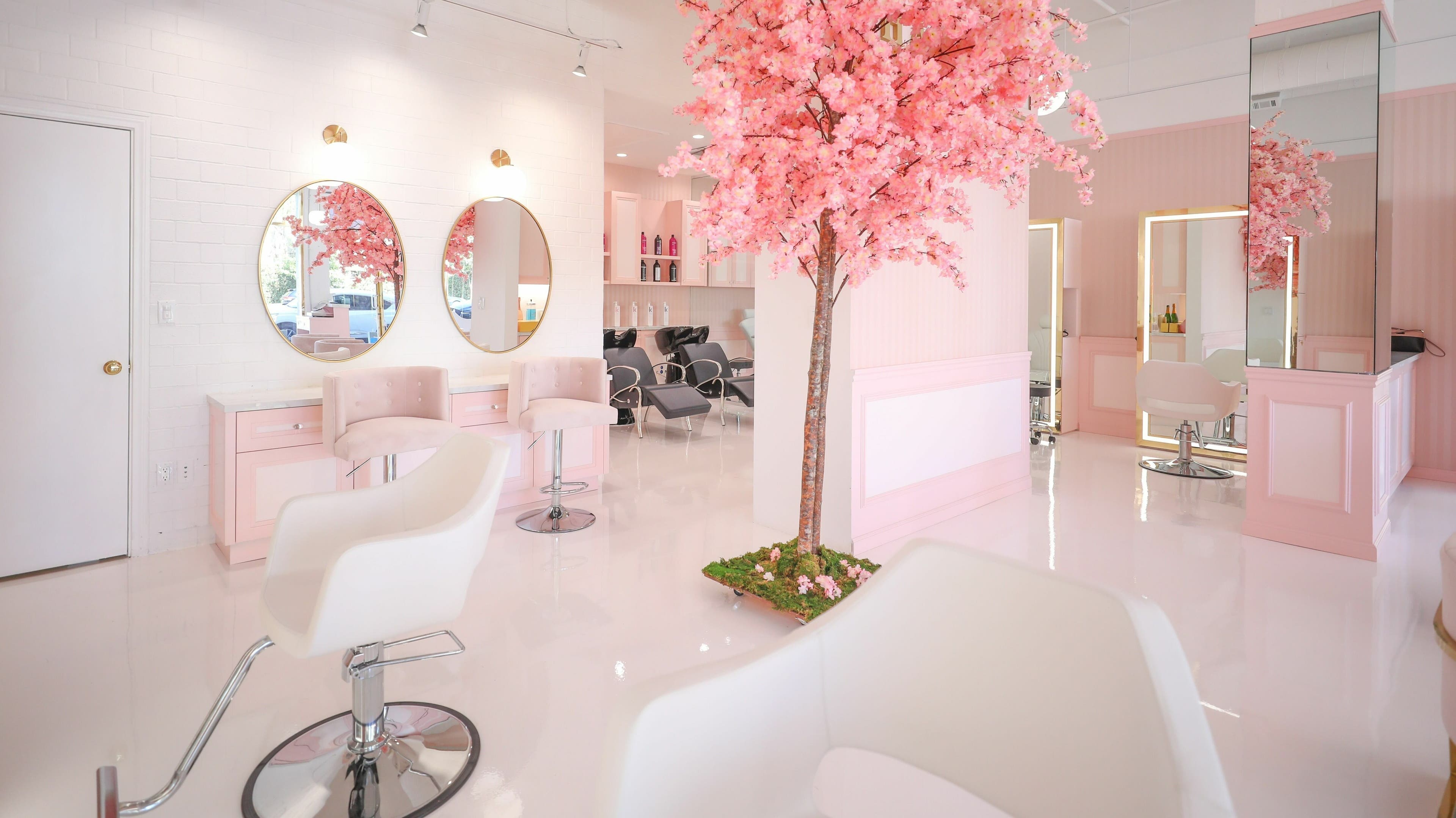 Chic interior of Brows by Alyssa HairBae Beauty Bar, Los Angeles, California, US, featuring pink decor and cherry blossoms.