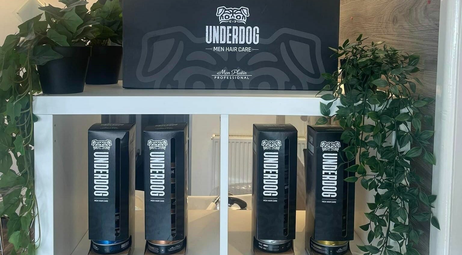 Underdog men's hair care products at Platform 169, Exeter, England, GB on a sleek shelf with decor.