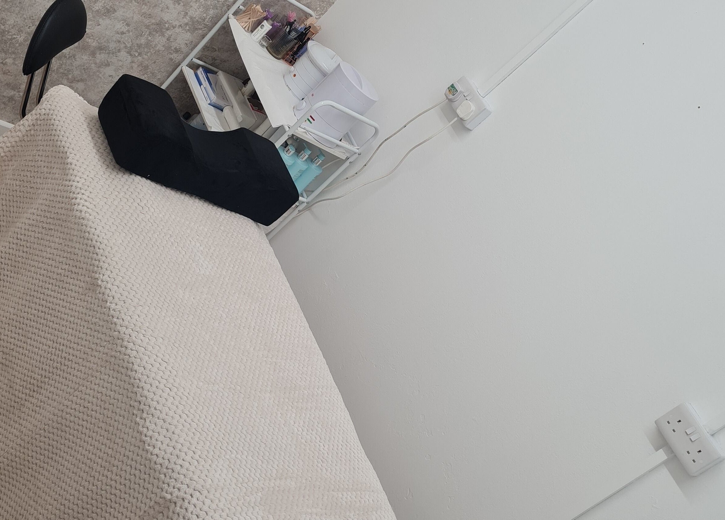 Cozy treatment room at Pampered Retreat, Bangor, Wales, GB, featuring a massage table and therapy essentials.