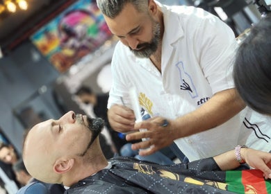 A skilled barber trimming a beard at Milado Cut Barber Shop, Dubai, Dubai, AE.