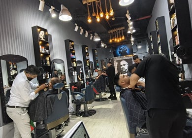 Stylish interior of Milado Cut Barber Shop in Dubai, Dubai, AE, showing barbers at work.