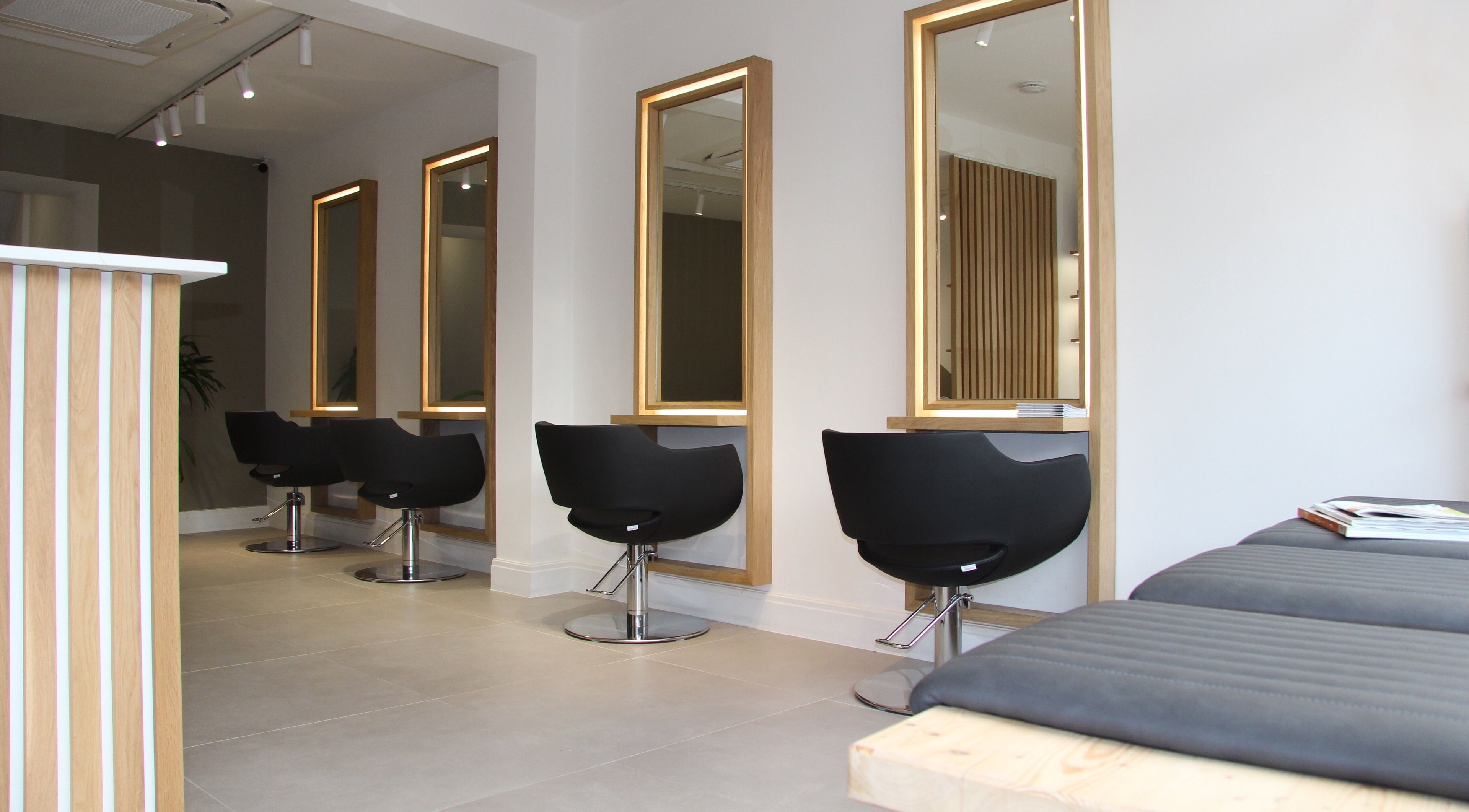 Elegant salon seating and mirrors at Venera Hair, London, England, GB, offering stylish hair services.