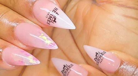 Stylish Hermès-themed nails at Myrie Beauty in Whitby, Ontario, CA. Elegant pink manicure with logo design.