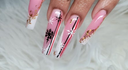 Elegant long nails with pink, white, and black snowflake design at Myrie Beauty in Whitby, Ontario, CA.