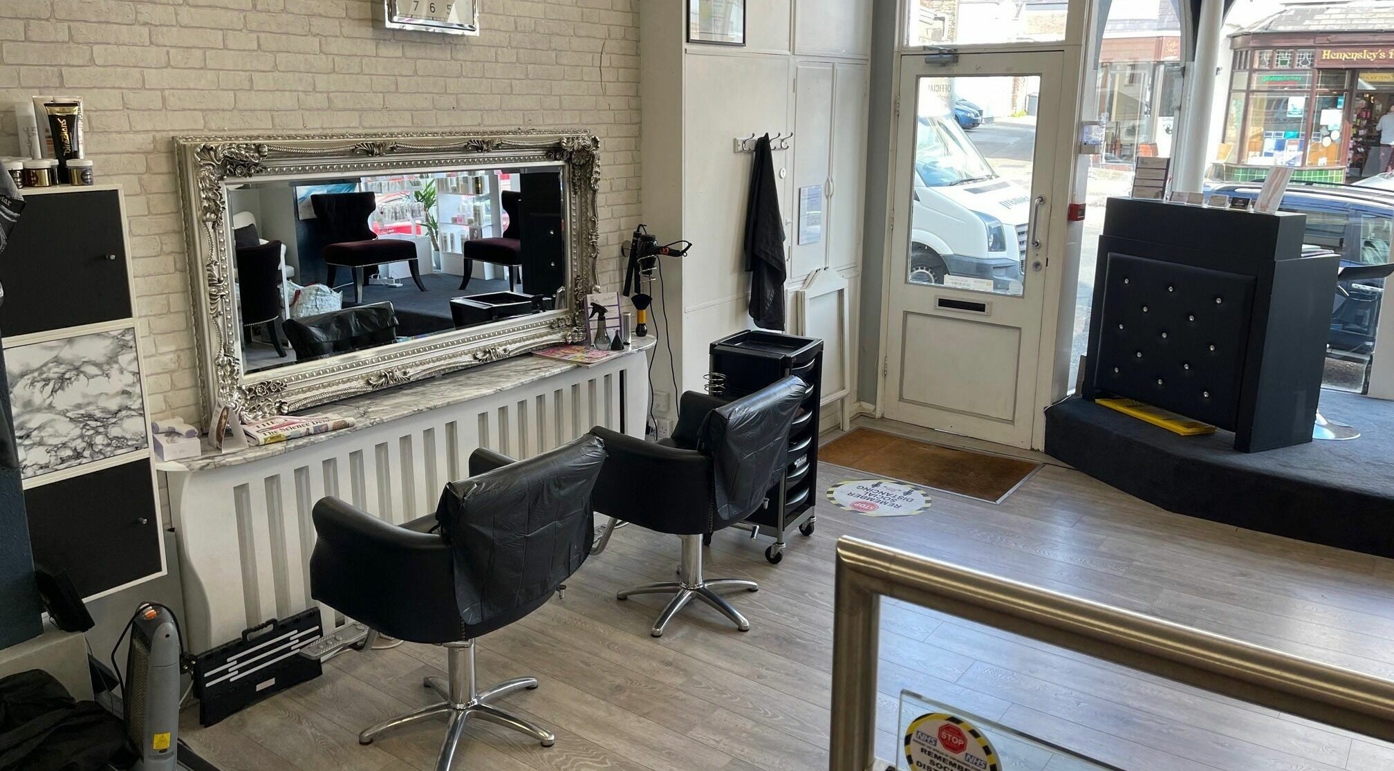 Chic interior of Magnificence Hair and Beauty in Douglas, Middle, IM with stylish mirror and salon chairs.