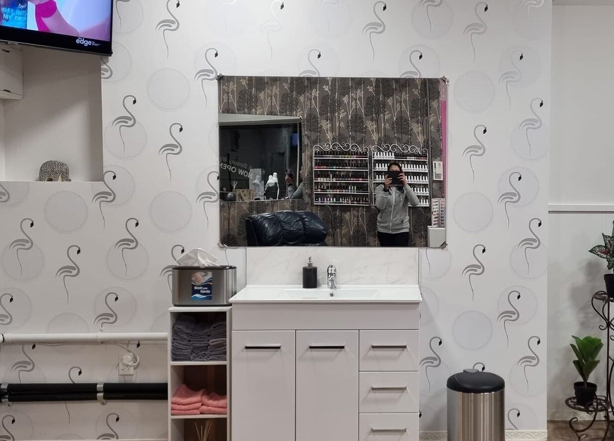 Elegant interior of Nails and Beauty by Irish in Dunedin, Otago, NZ with a stylish wall mirror and plant decor.
