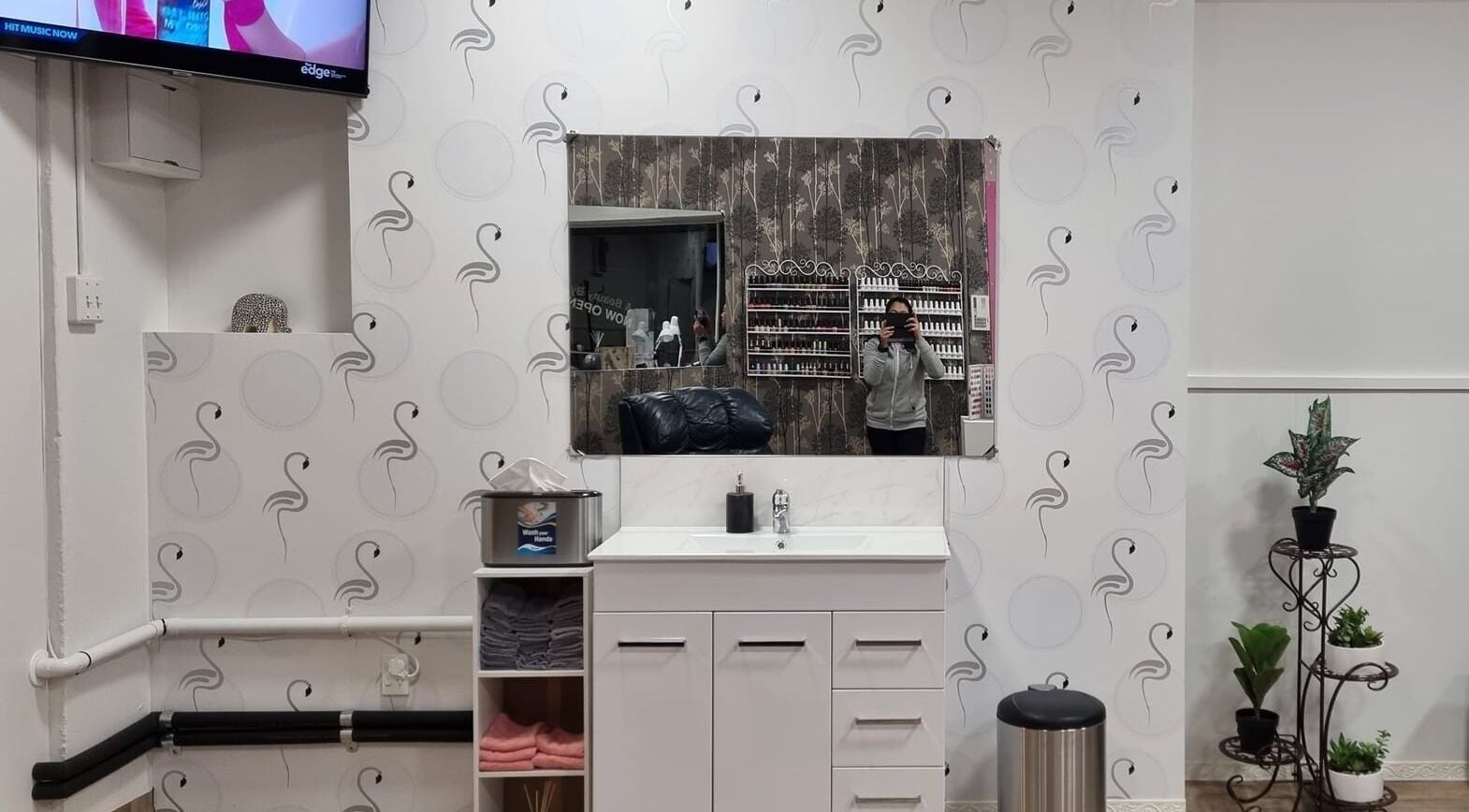 Elegant interior of Nails and Beauty by Irish in Dunedin, Otago, NZ with a stylish wall mirror and plant decor.