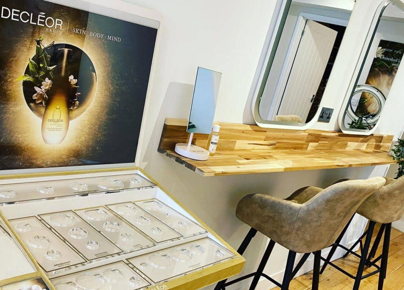 Elegant beauty setup at River and Rose, Dartmouth, England, GB with Decleor display and wooden vanity.