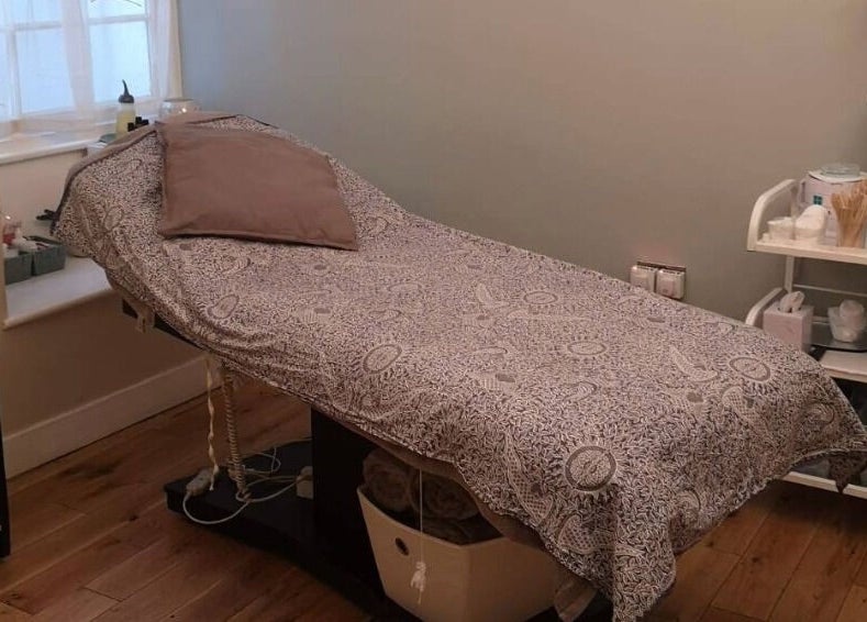 Cozy treatment room at River and Rose, Dartmouth, England, GB, featuring a comfortable therapy bed and amenities.