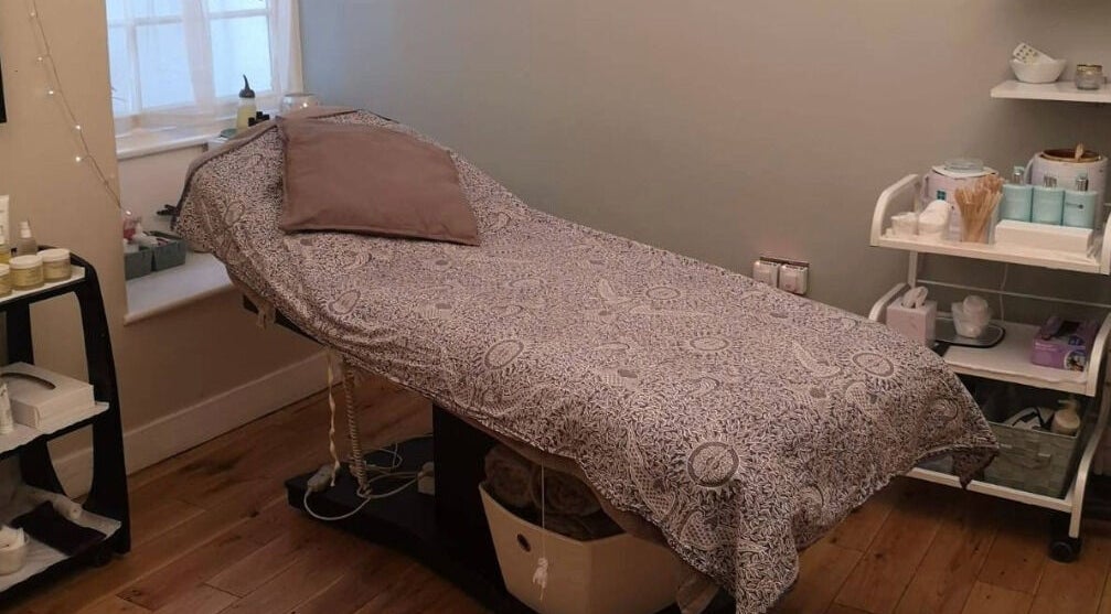 Cozy treatment room at River and Rose, Dartmouth, England, GB, featuring a comfortable therapy bed and amenities.