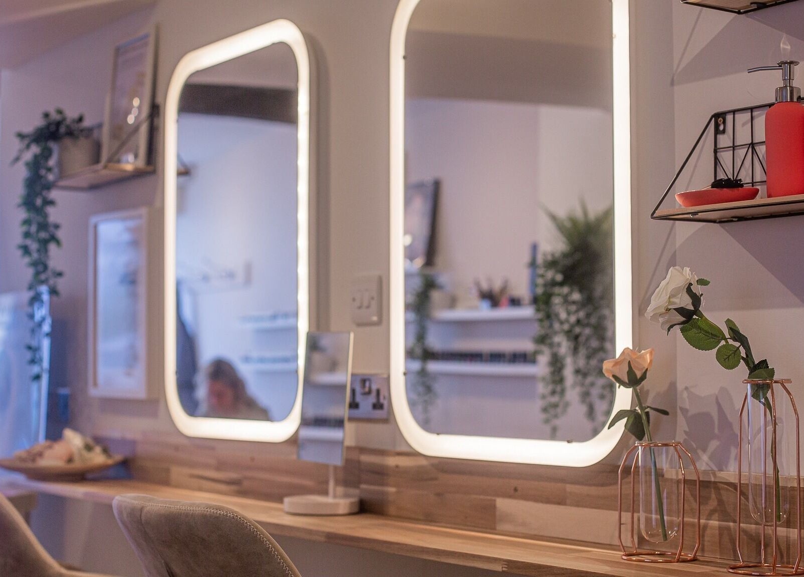 Chic beauty setup at River and Rose, Dartmouth, England, GB featuring illuminated mirrors and decorative plants.