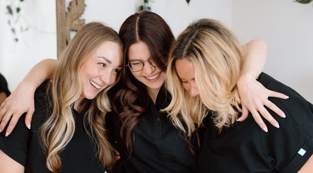 Smiling team at Sweet Beauty Esthetics in Kitchener, Ontario, CA, embracing warmly.