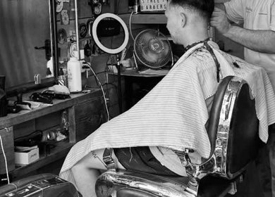 Customer getting a haircut at Bell St. Barbers, North Shields, England, GB with vintage decor.