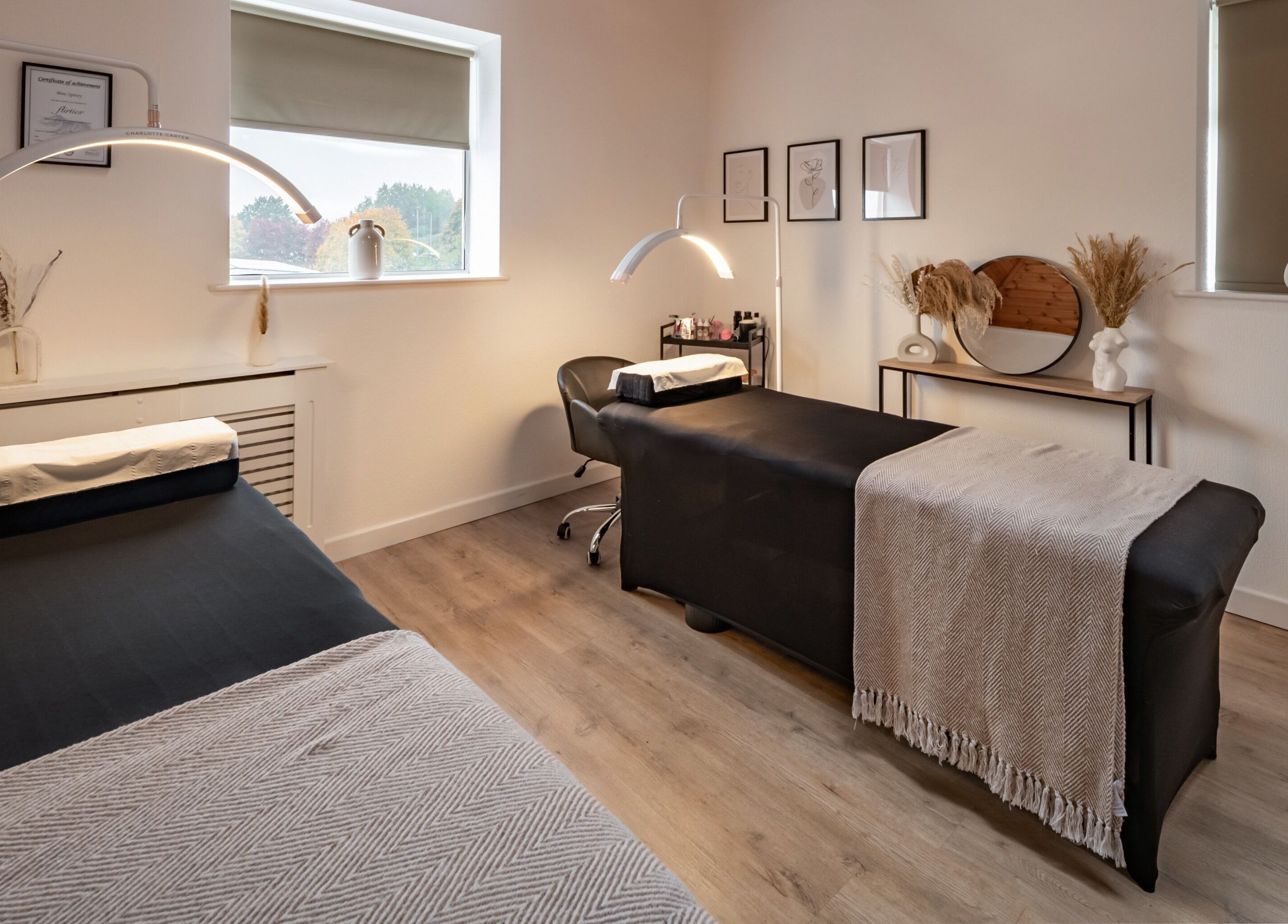 Modern treatment room at Bree Spivey Cosmetics, Exeter, England, GB, featuring two massage tables and elegant decor.