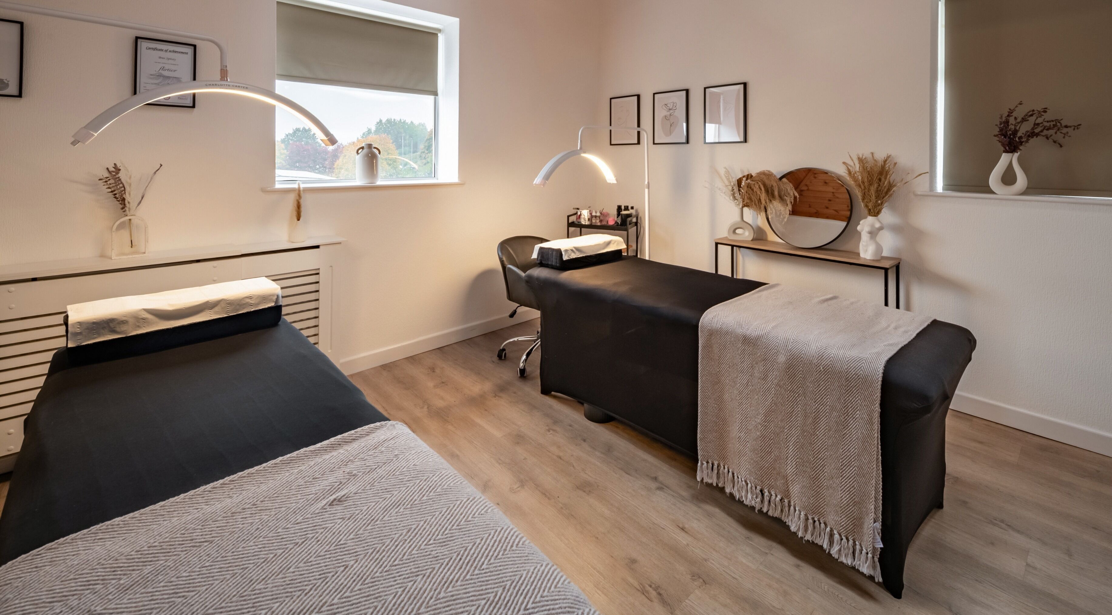 Modern treatment room at Bree Spivey Cosmetics, Exeter, England, GB, featuring two massage tables and elegant decor.