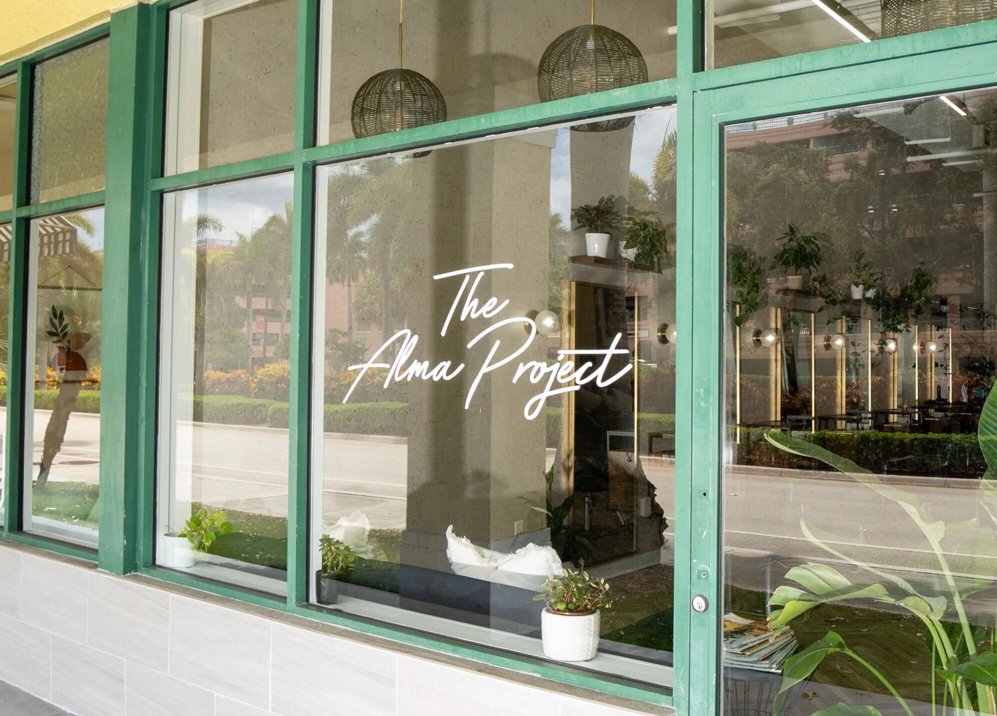 Sophisticated entrance of Color by Gia x Vion Boutique Salon, Boca Raton, Florida, reflecting lush greenery.