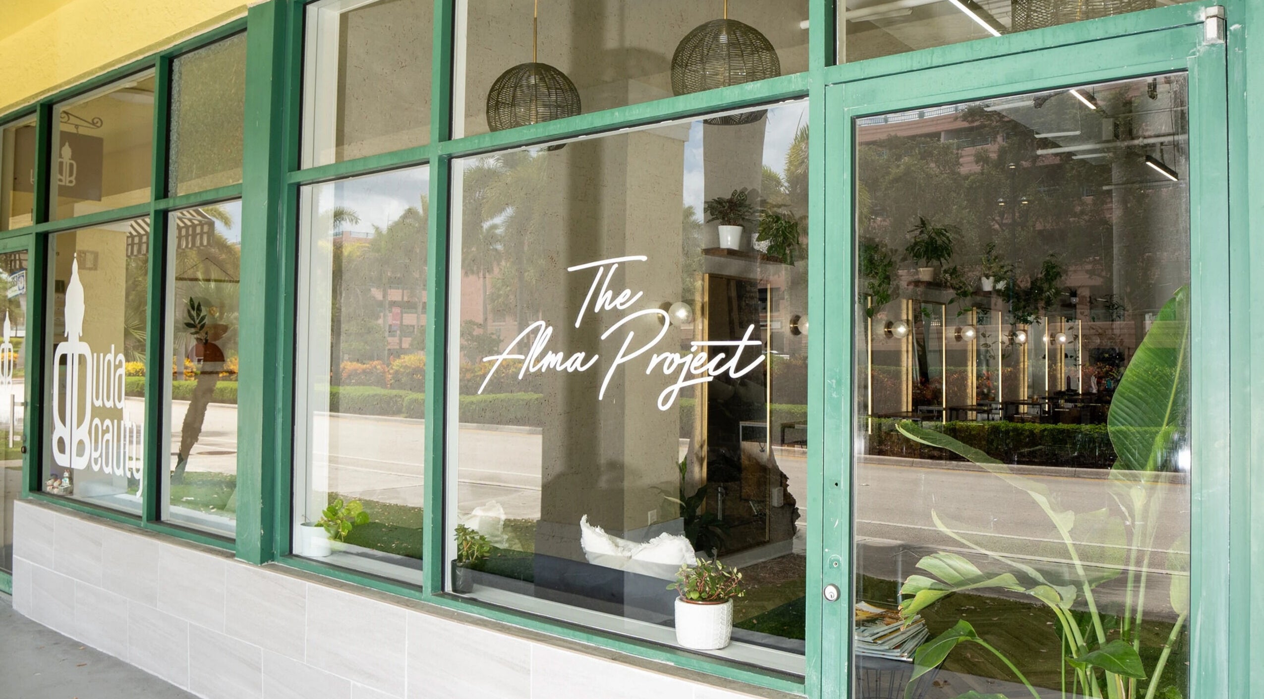 Sophisticated entrance of Color by Gia x Vion Boutique Salon, Boca Raton, Florida, reflecting lush greenery.