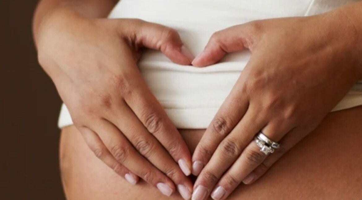 Hands forming a heart on a belly at The Little Gem Spa Massage, North Perth, Western Australia, AU.