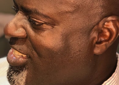 Close-up of a man enjoying a haircut at The Alpha Male Barbershop, Nassau, New Providence, BS.