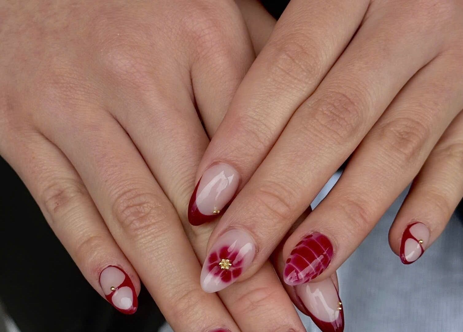 Beautifully manicured nails with red floral design at TH Nails and Spa Geelong West, Geelong West, Victoria, AU.