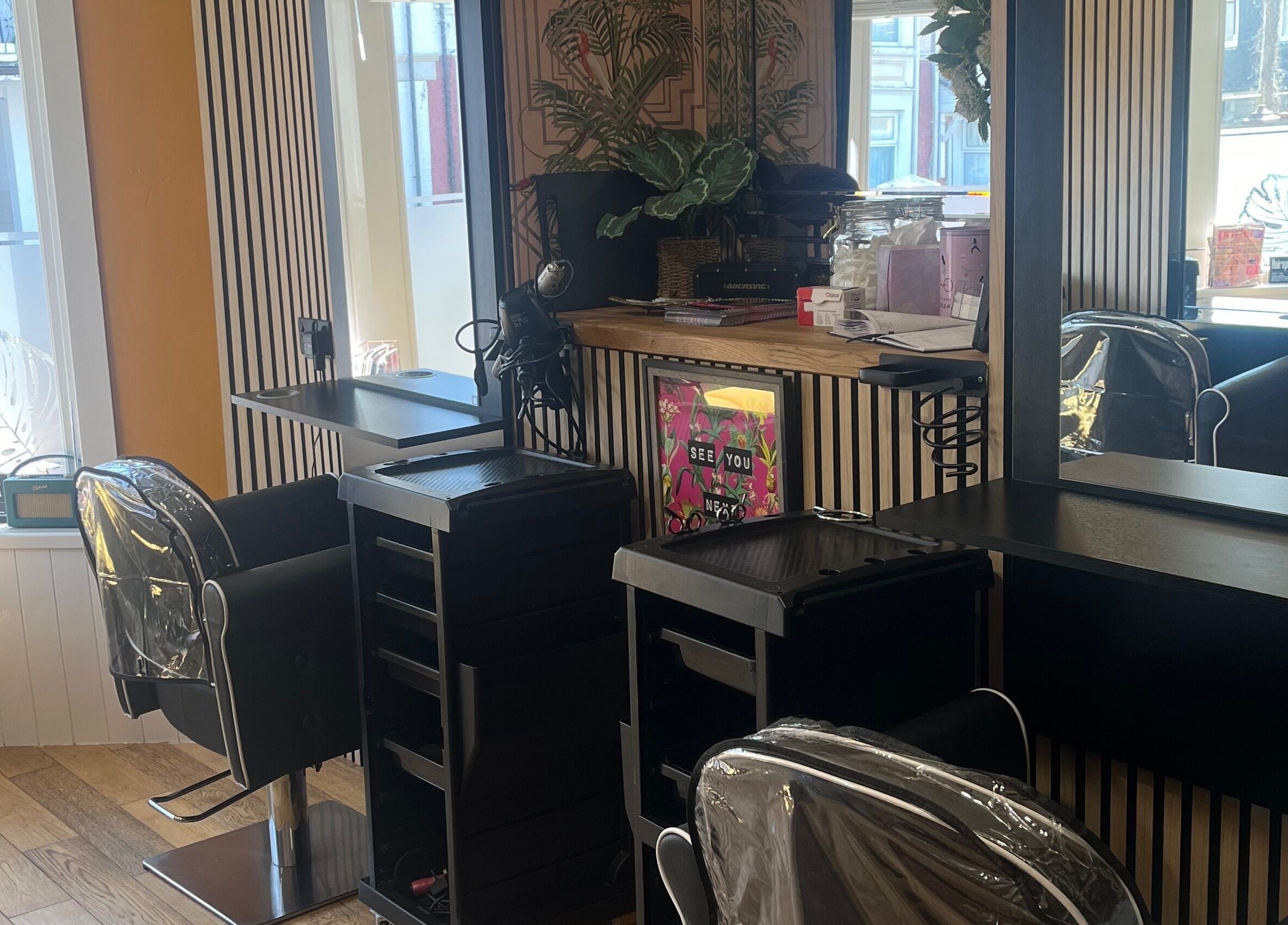 Modern salon setup at Knock Knock Who’s Hair?, Porthcawl, Wales, GB with elegant styling chairs and mirrors.