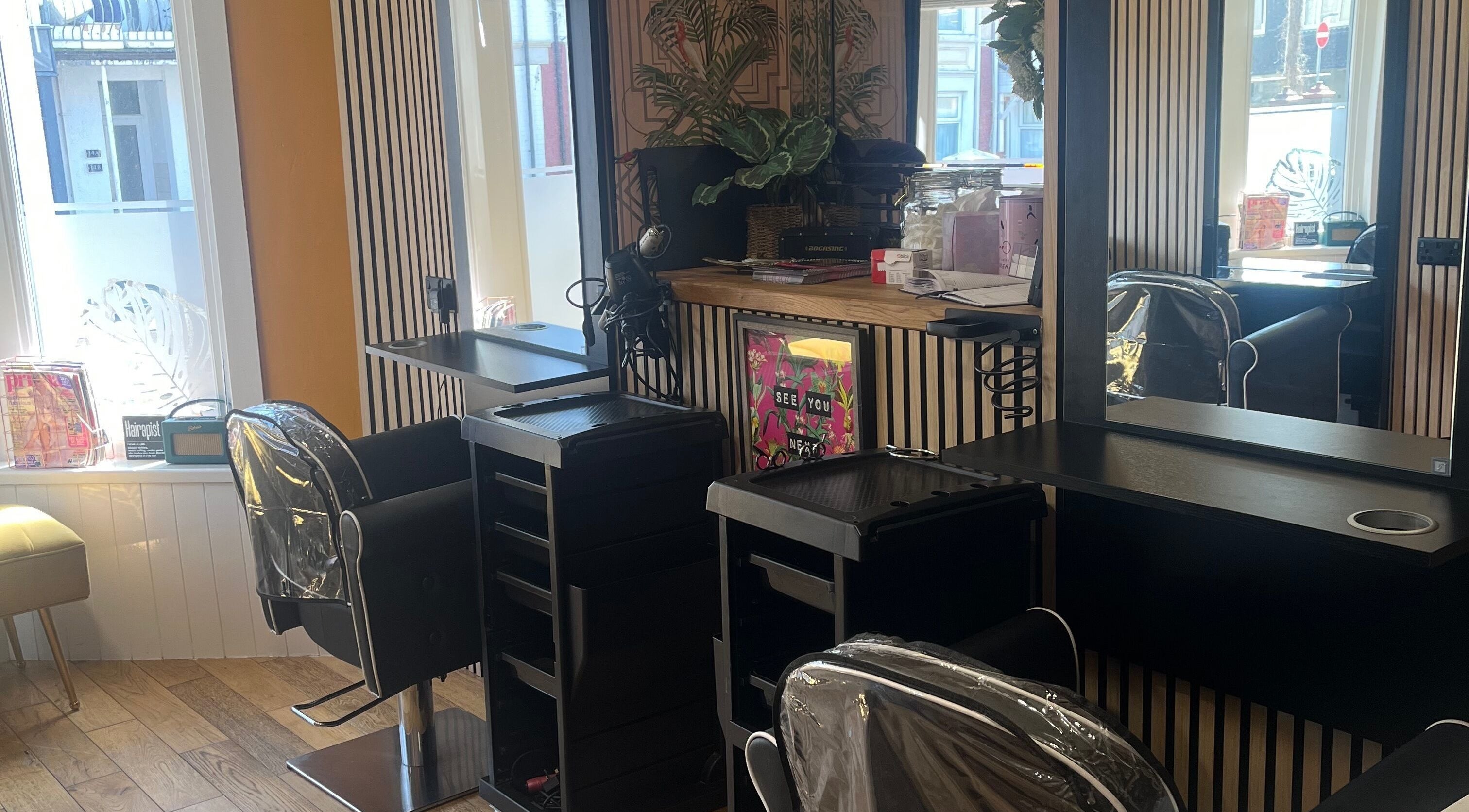 Modern salon setup at Knock Knock Who’s Hair?, Porthcawl, Wales, GB with elegant styling chairs and mirrors.