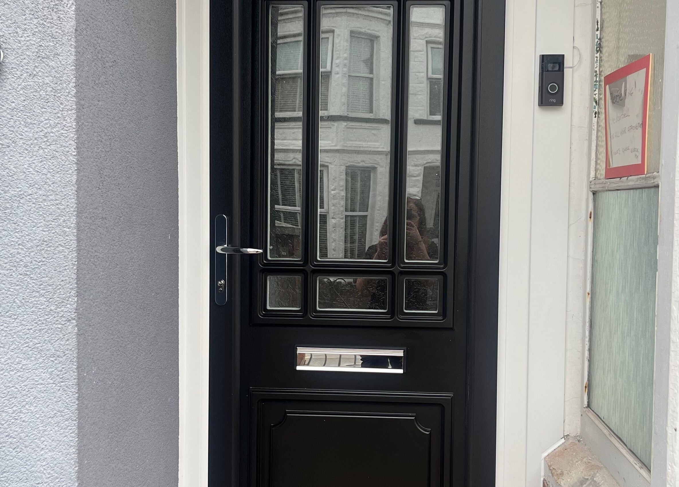 Sleek black entrance door of Knock Knock Who’s Hair, Porthcawl, Wales, GB. Modern and inviting entryway.
