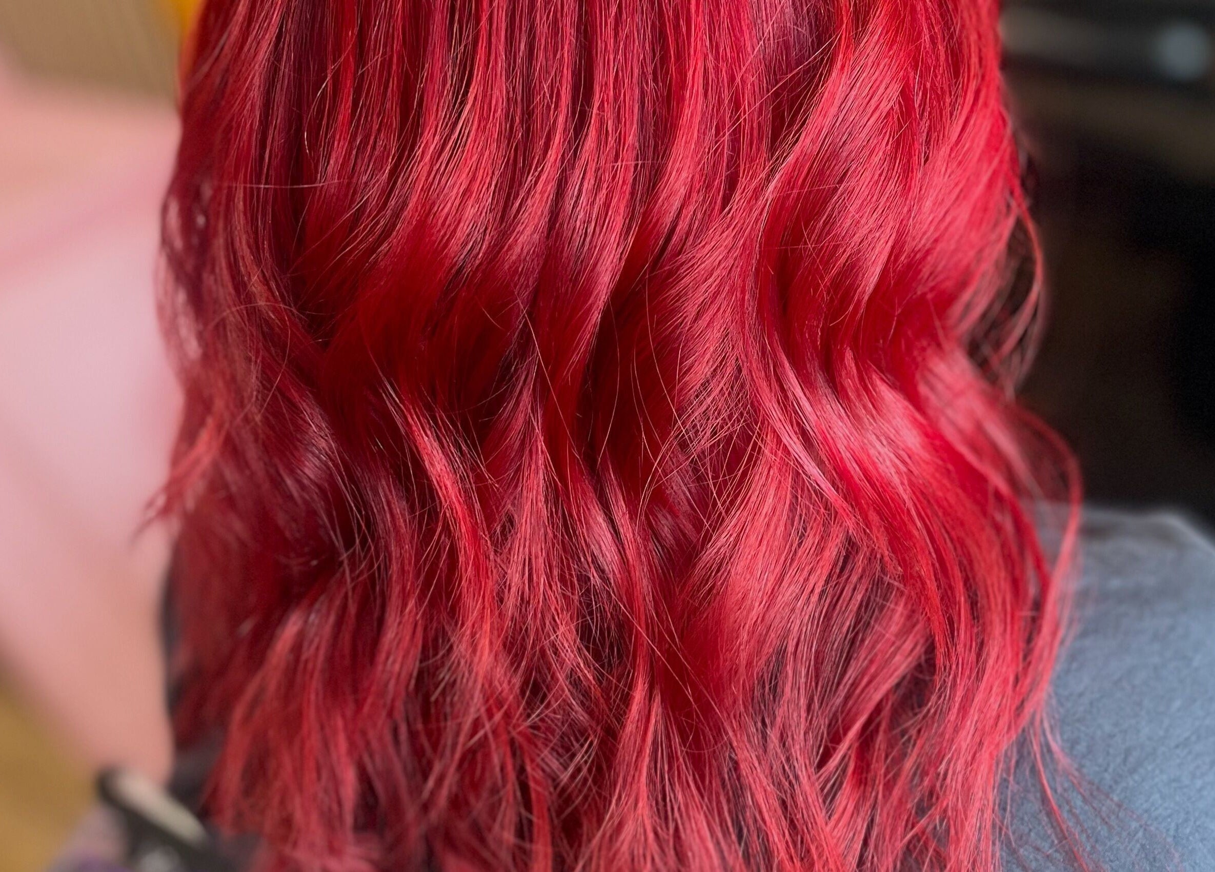 Vibrant red wavy hair styled at Knock Knock Who’s Hair?, Porthcawl, Wales, GB.