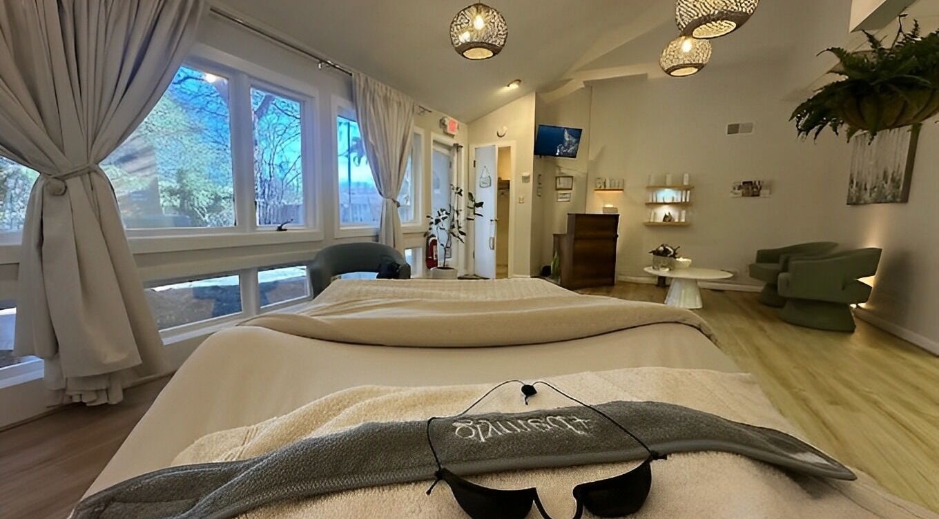 Relaxing spa room at The Skin Tune in Ramsey, New Jersey, US, featuring cozy seating and soft lighting.