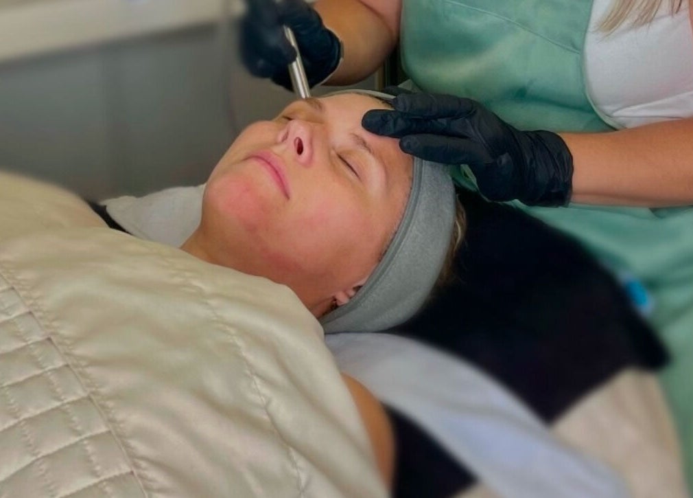 Facial treatment at The Skin Tune in Ramsey, New Jersey, US. Aesthetician using tool on client's face.