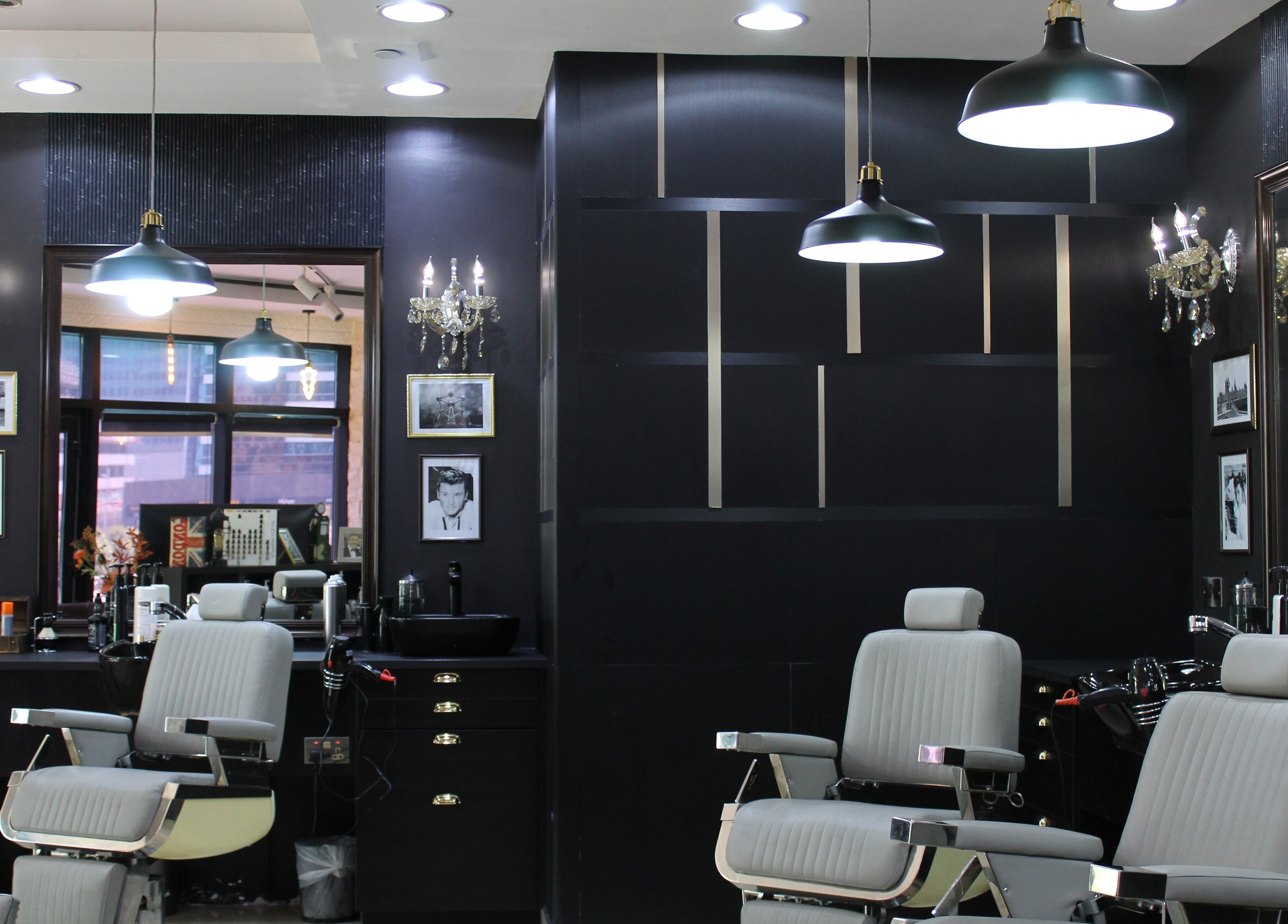 Interior of James Pro Barbers in Dubai, Dubai, AE, showcasing modern black and grey decor with stylish furnishings.