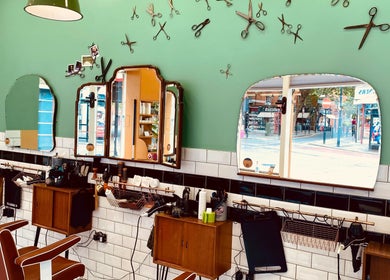 Vintage-inspired interior of Barber Streisand in London, England, GB featuring classic barber chairs and mirrors.