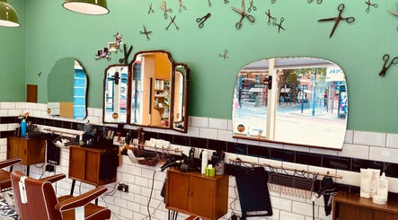 Vintage-inspired interior of Barber Streisand in London, England, GB featuring classic barber chairs and mirrors.