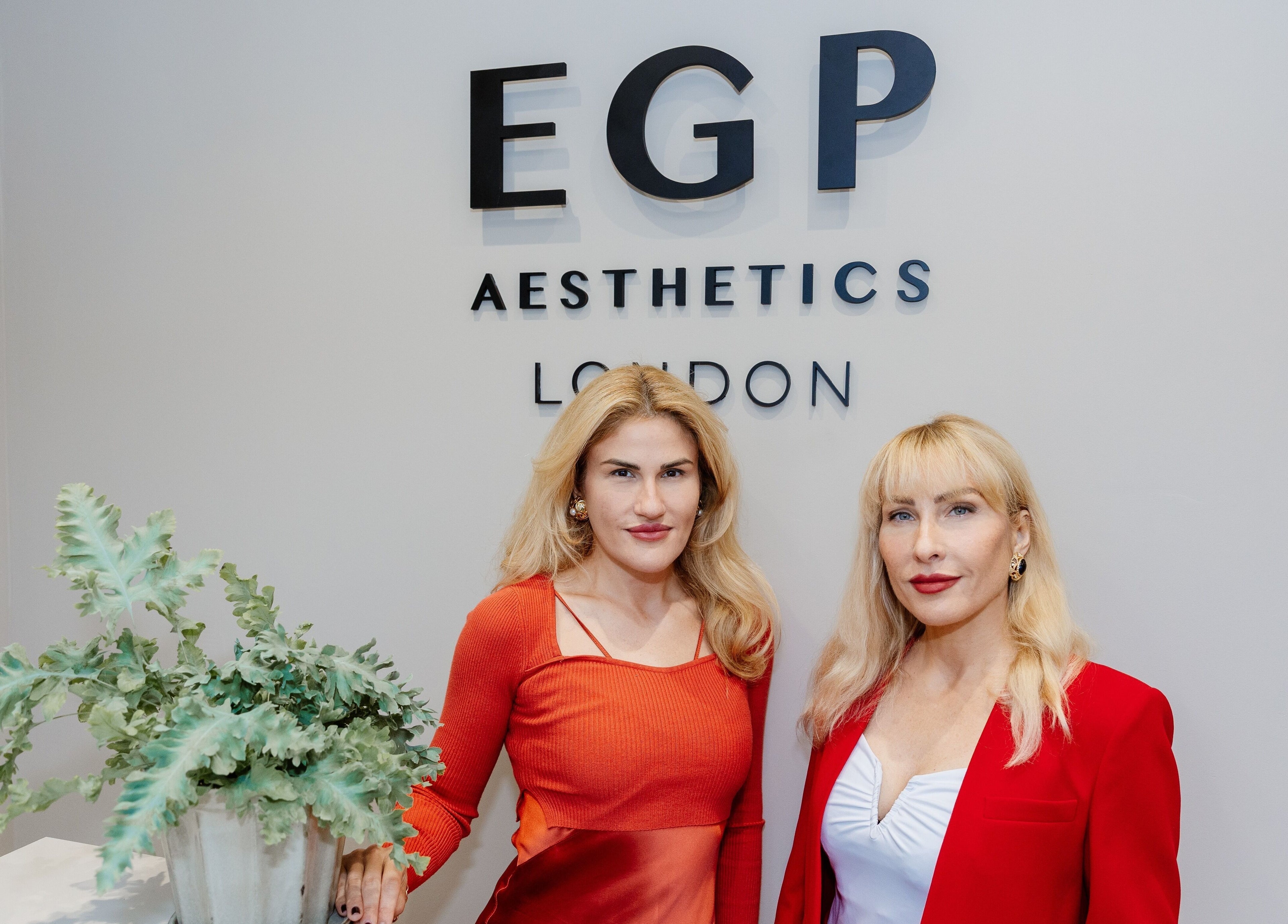 Two people at EGP Aesthetics, London, England, GB, standing in front of the venue's sign.