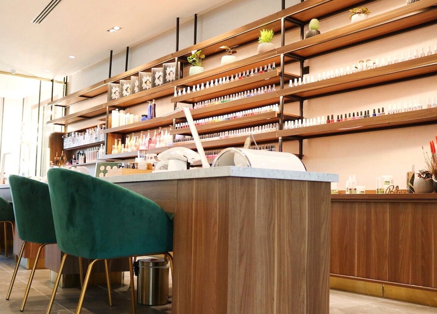 Chic interior of Gloss'd Beauty Lounge | Khobar, with green chairs and product shelves, Al Khobar, Eastern Province, SA.