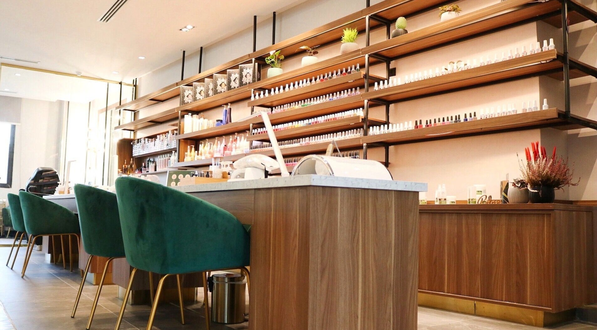 Chic interior of Gloss'd Beauty Lounge | Khobar, with green chairs and product shelves, Al Khobar, Eastern Province, SA.
