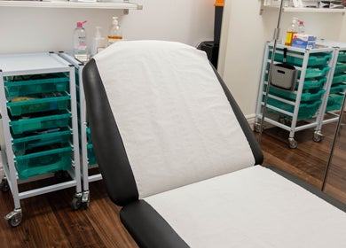 Treatment room at Barbanente Clinic, London, England, GB with a comfortable chair and organized supplies.