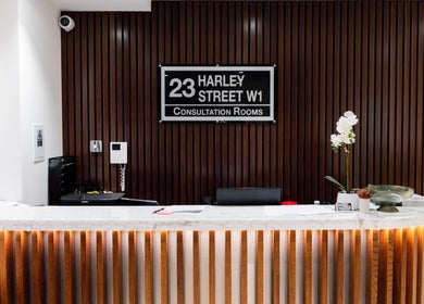 Elegant reception desk at Barbanente Clinic, London, England, GB with modern decor and ambient lighting.