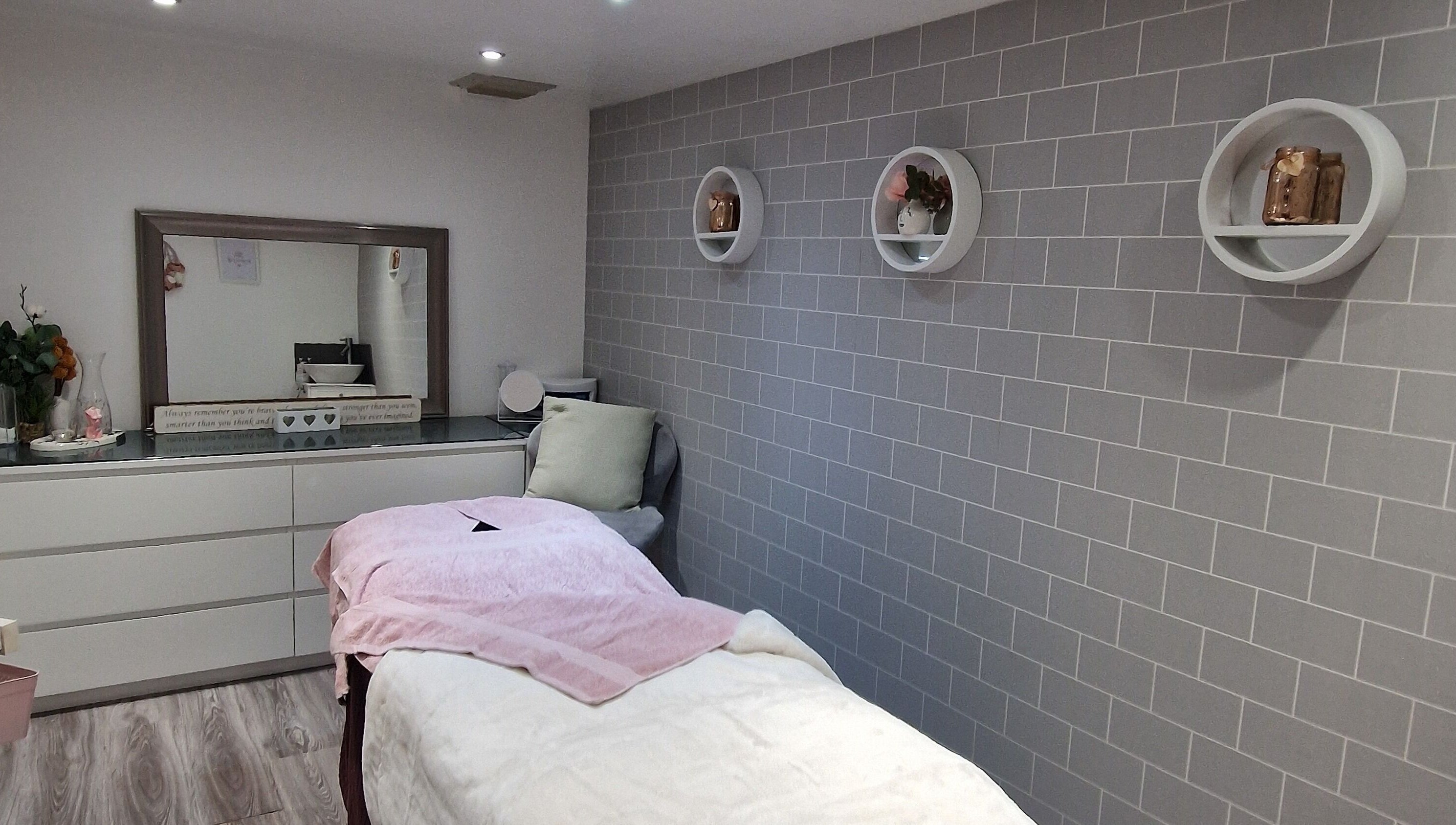 Cozy treatment room at Adore Beauty, Aberdeen, Scotland, GB, featuring a plush bed and modern decor.