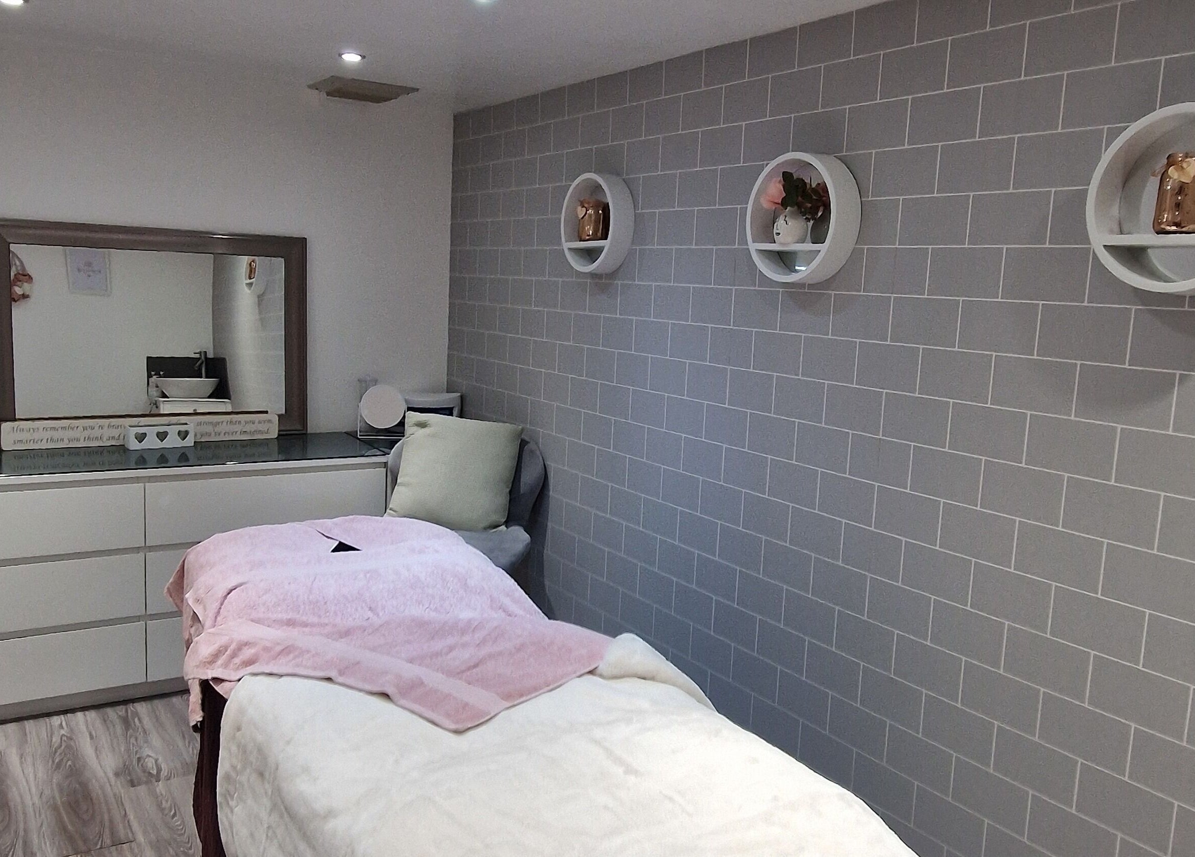 Cozy treatment room at Adore Beauty, Aberdeen, Scotland, GB, featuring a plush bed and modern decor.