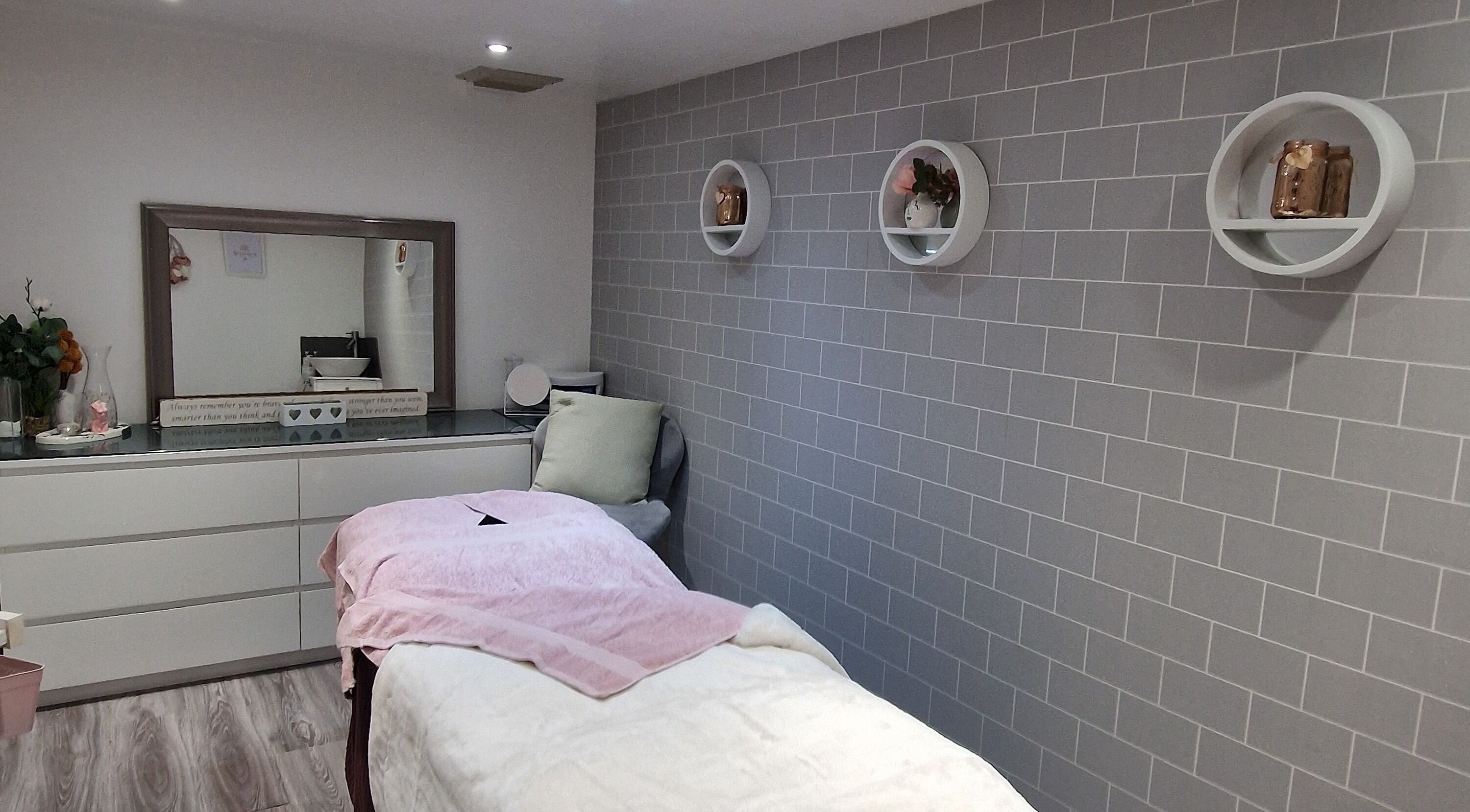 Cozy treatment room at Adore Beauty, Aberdeen, Scotland, GB, featuring a plush bed and modern decor.