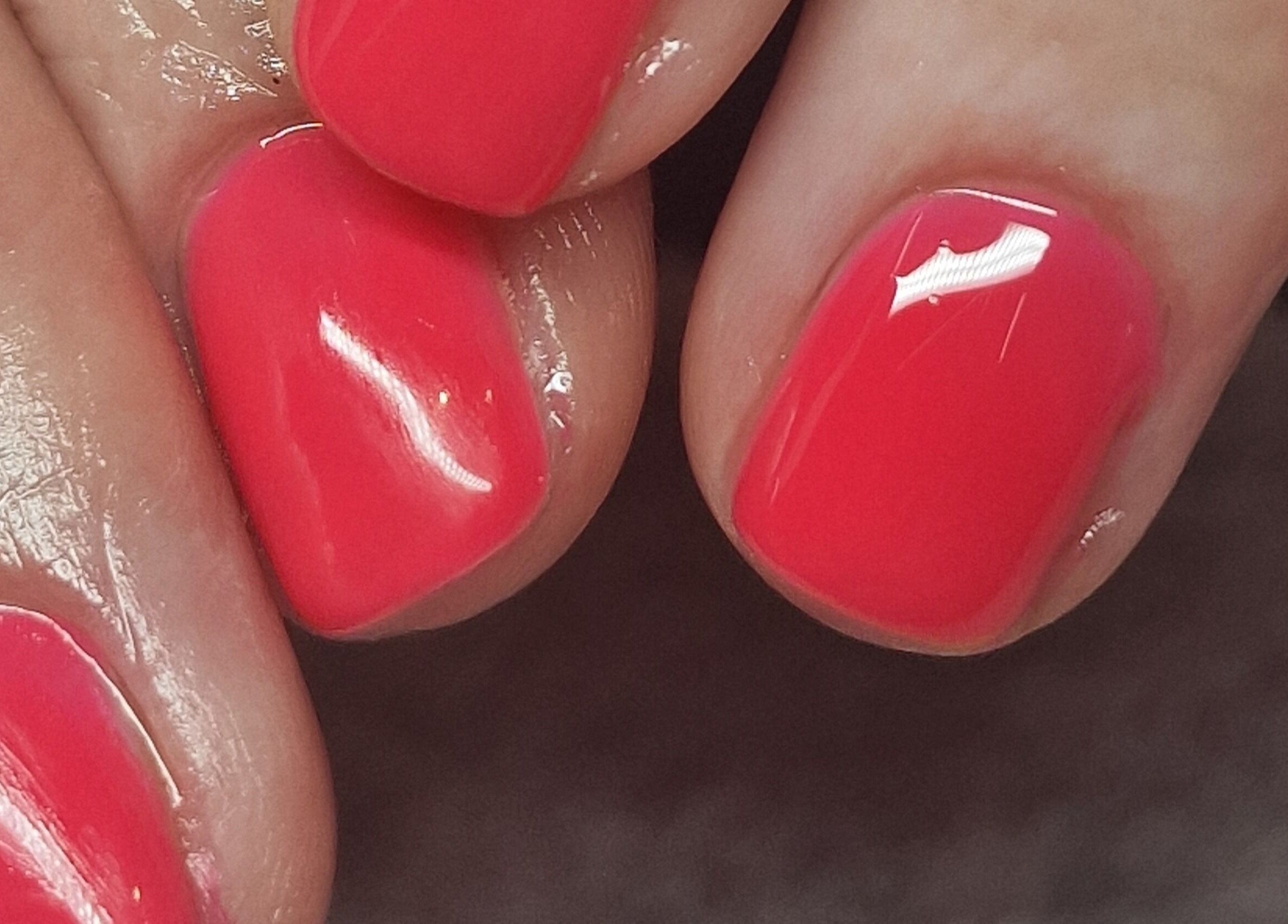 Vibrant red manicure at Adore Beauty in Aberdeen, Scotland, GB. Elegant nail care detail.