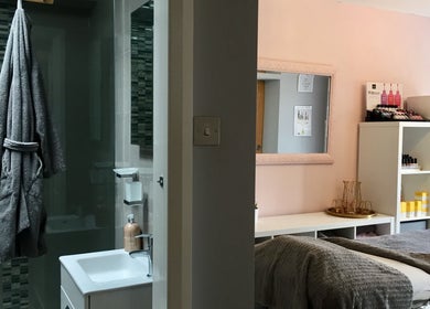 Cozy treatment room at LHB, London Colney, England, GB featuring soft grey towels and wellness products.