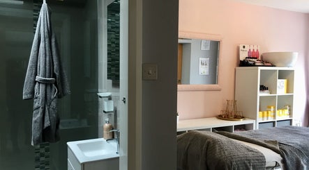 Cozy treatment room at LHB, London Colney, England, GB featuring soft grey towels and wellness products.