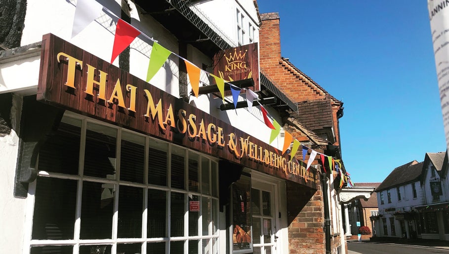 Entrance of King Thai Therapy Knowle in Knowle, England, GB, decorated with colorful flags.